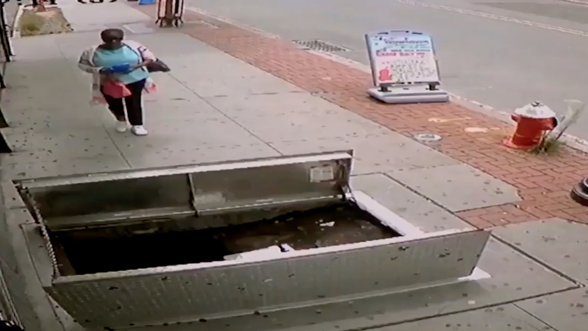 Watch as woman distracted by cellphone falls into sidewalk opening